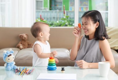 Cheerful mother and her little daughter enjoying playing together